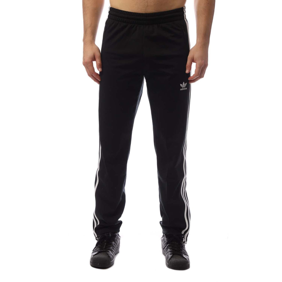 Black track pants with elastic waistband and side stripes, Adidas trefoil logo