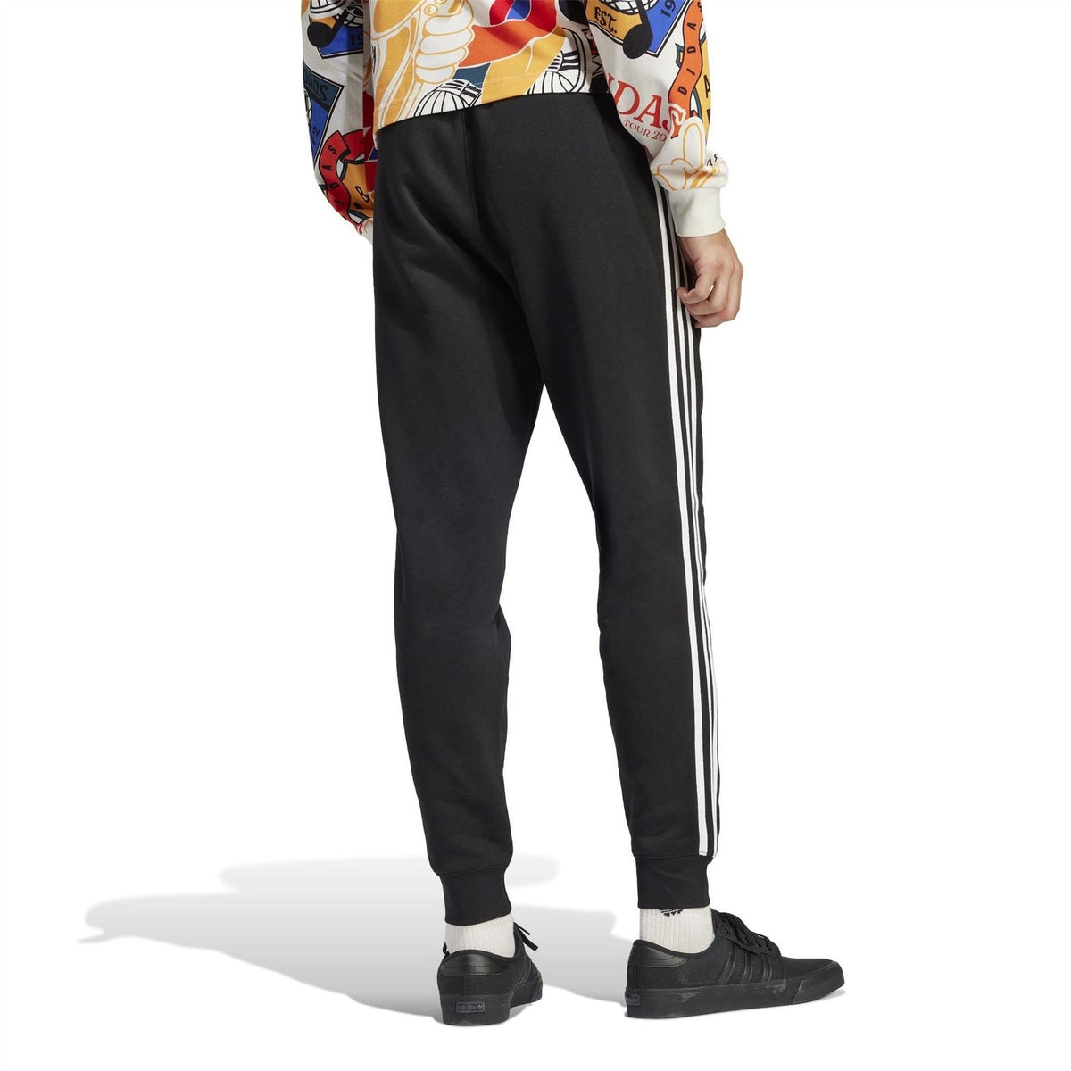 Black slim joggers with white side stripes and ribbed cuffs, full-body view