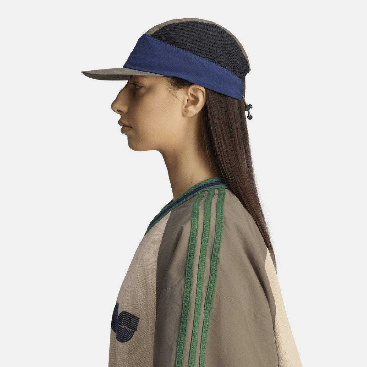 Two-tone cap on model, olive crown and brim with blue band, side mesh panel