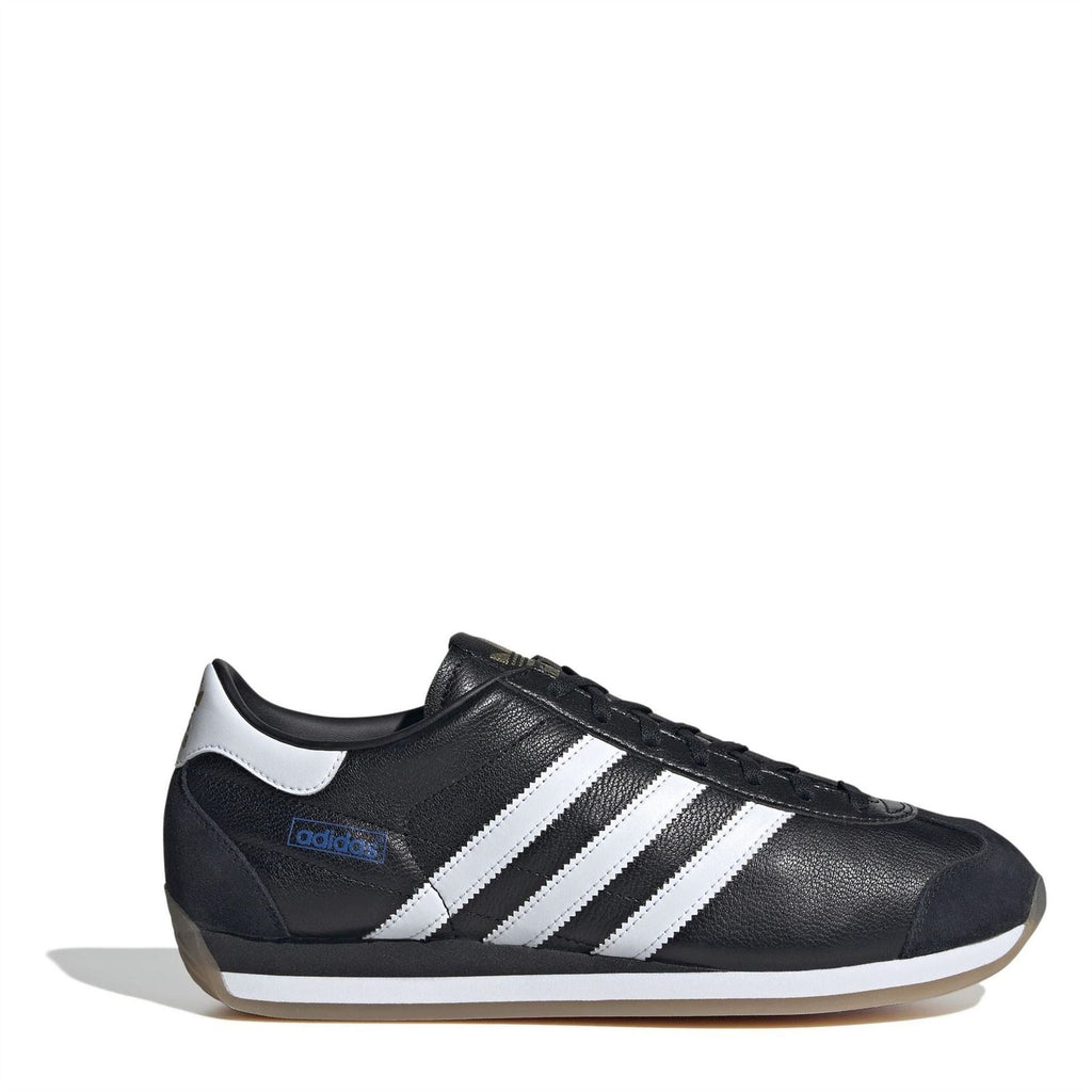 Black leather low-top sneakers with white three-stripe design, lace-up front, gum sole.