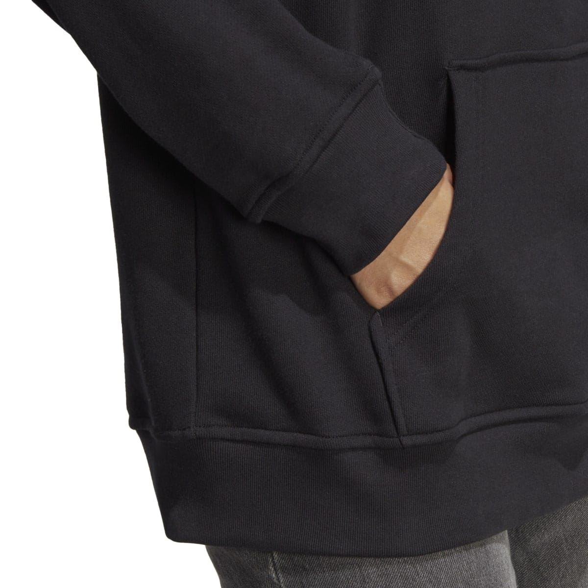 Close-up of black hoody sleeve and kangaroo pocket hem cuff detail