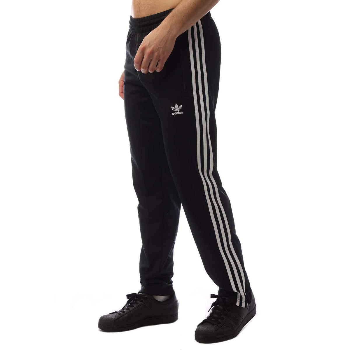 Black track pants with white triple side stripes and small Adidas trefoil logo