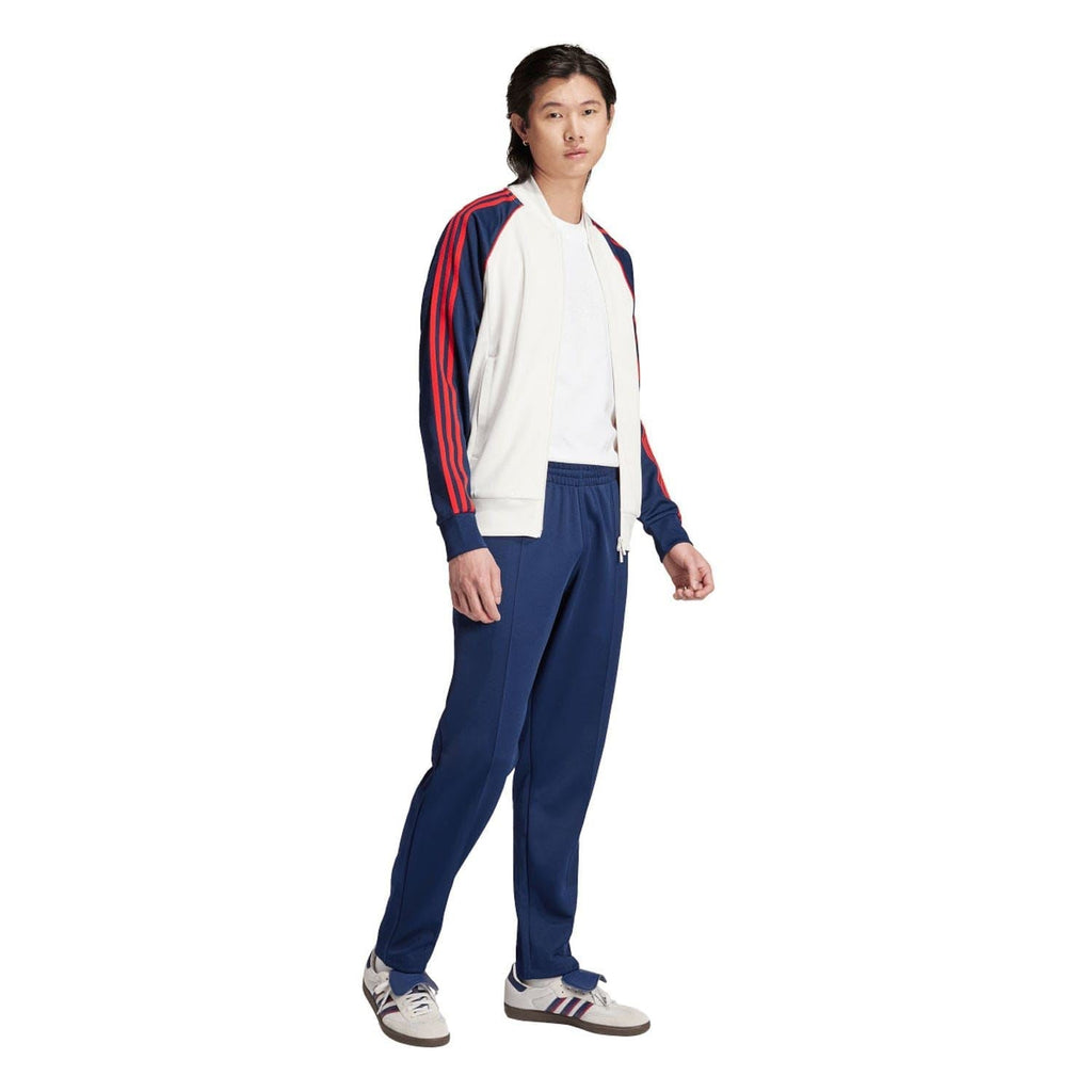 White track jacket worn with matching pants, navy sleeves with red stripes, full zip