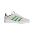 White low-top trainers with green triple stripes and lace-up front.