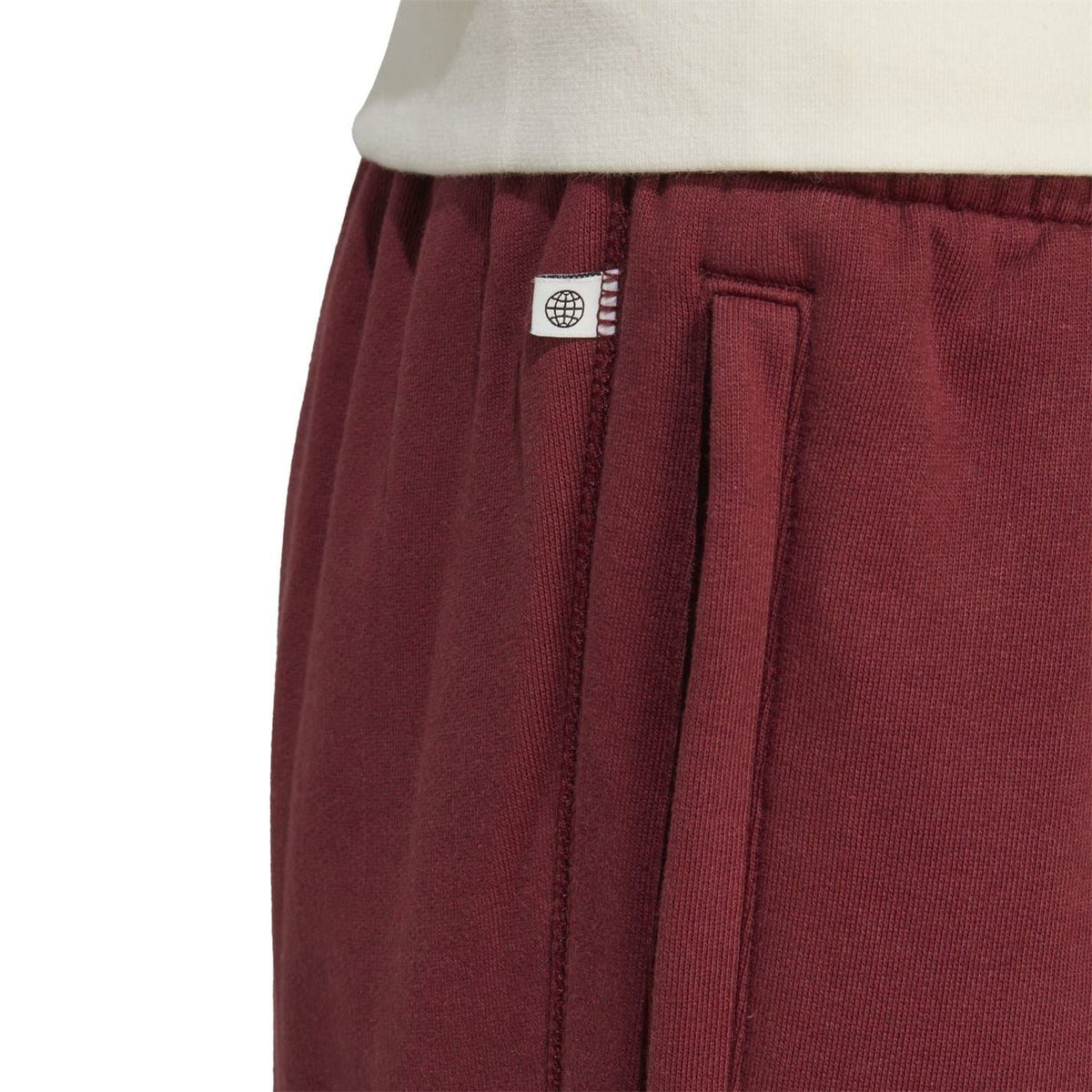Burgundy pants pocket and panel detail with welt pocket and vertical trim stitching