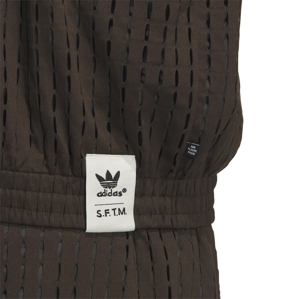 Brown jacket sleeve label area with adidas Trefoil and S.F.T.M. text patch