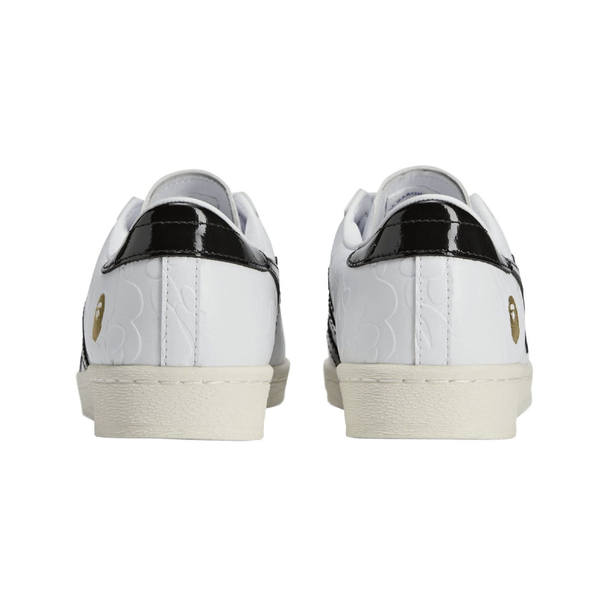 White sneakers with black heel tab, beige sole, and perforated panel detail