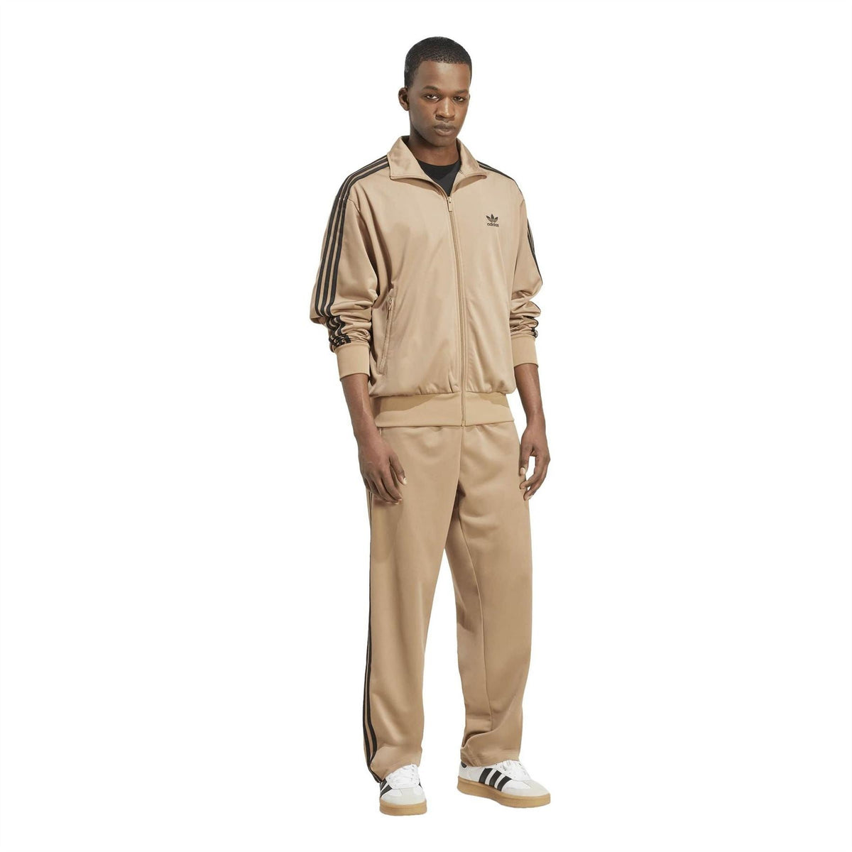 Tan adidas track jacket worn with matching pants, black side stripes, ribbed cuffs.