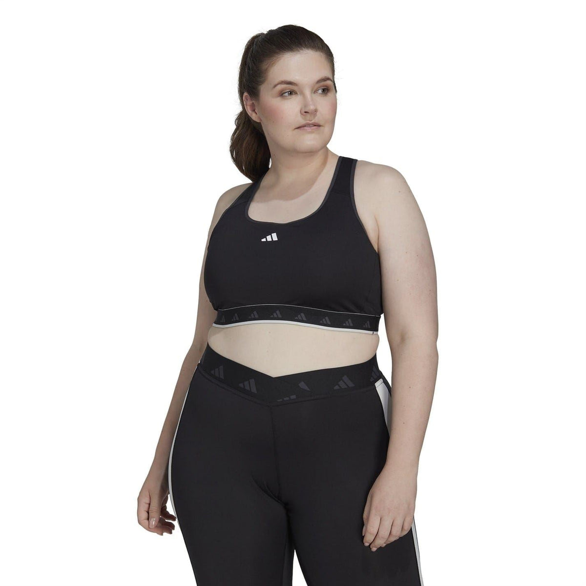 Black scoop-neck sleeveless bra top on model with Adidas logo