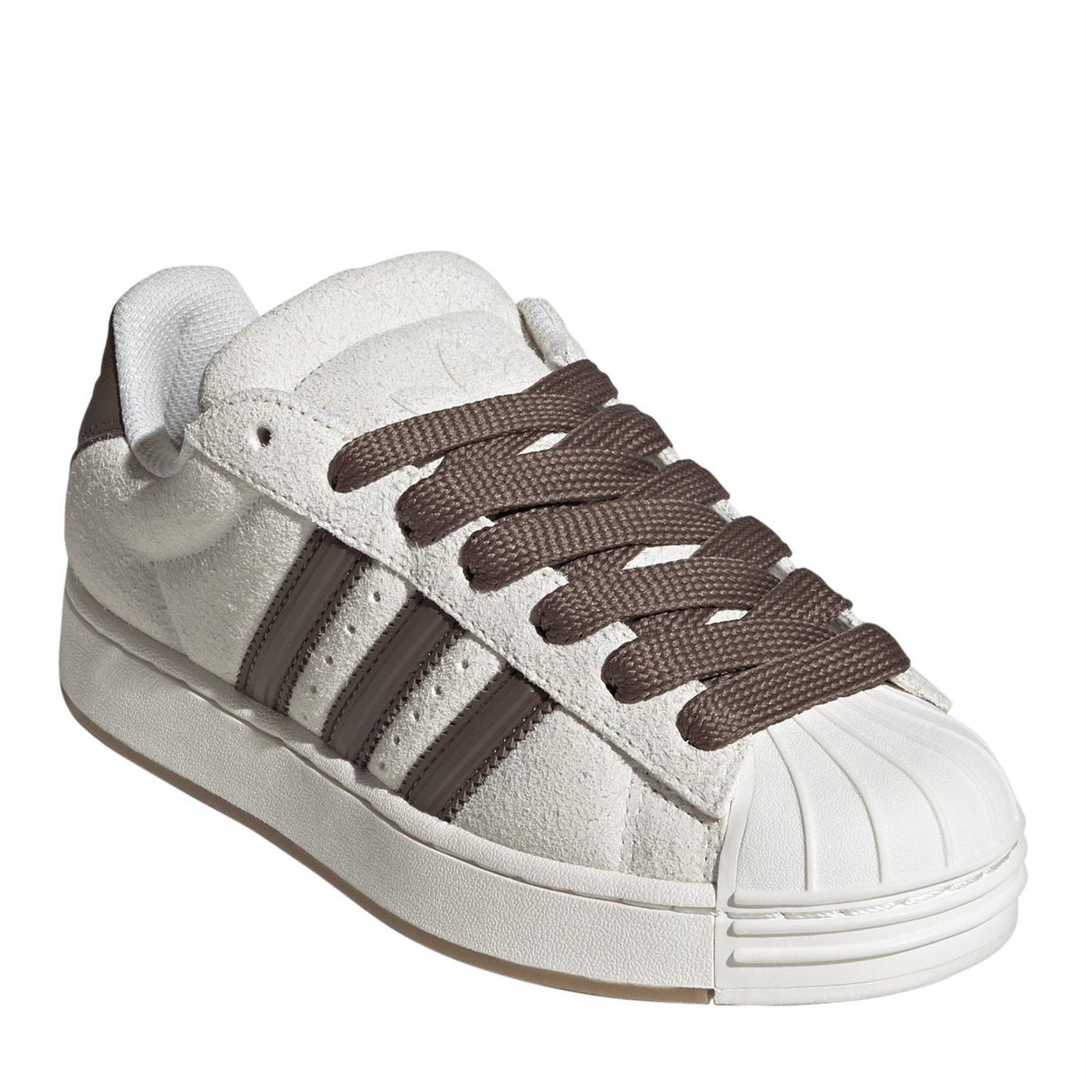 Off-white low-top sneakers with brown lace-up, suede texture, and iconic white shell toe.