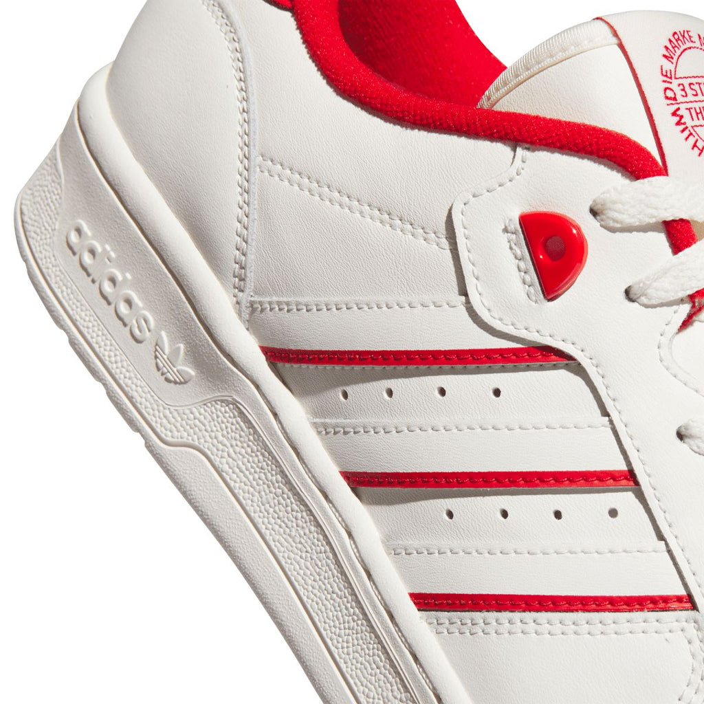 White leather upper with red stripe detailing and lace eyelet panels.