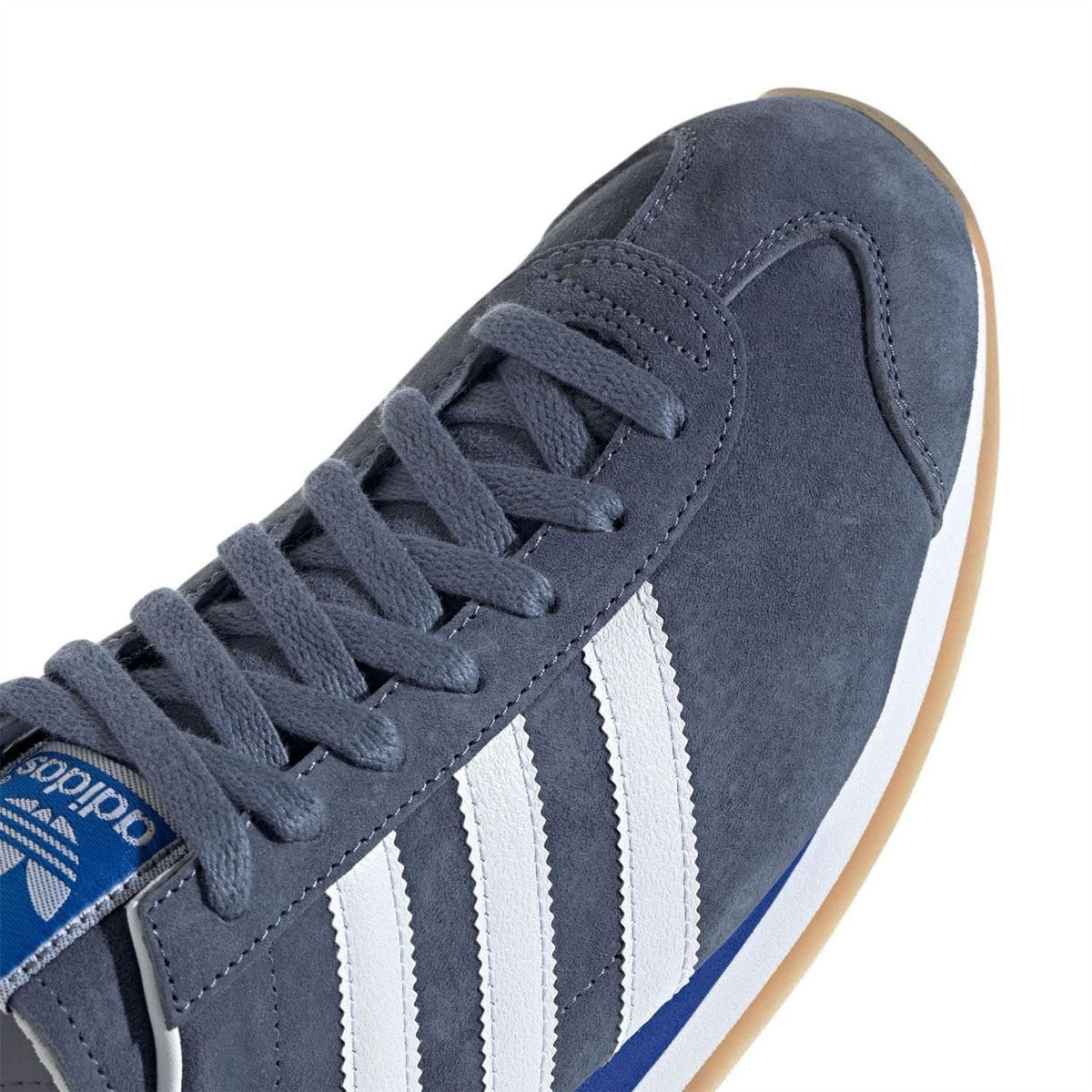 Navy adidas Originals Japan trainers, close-up of lace, suede panel, and white stripe overlays