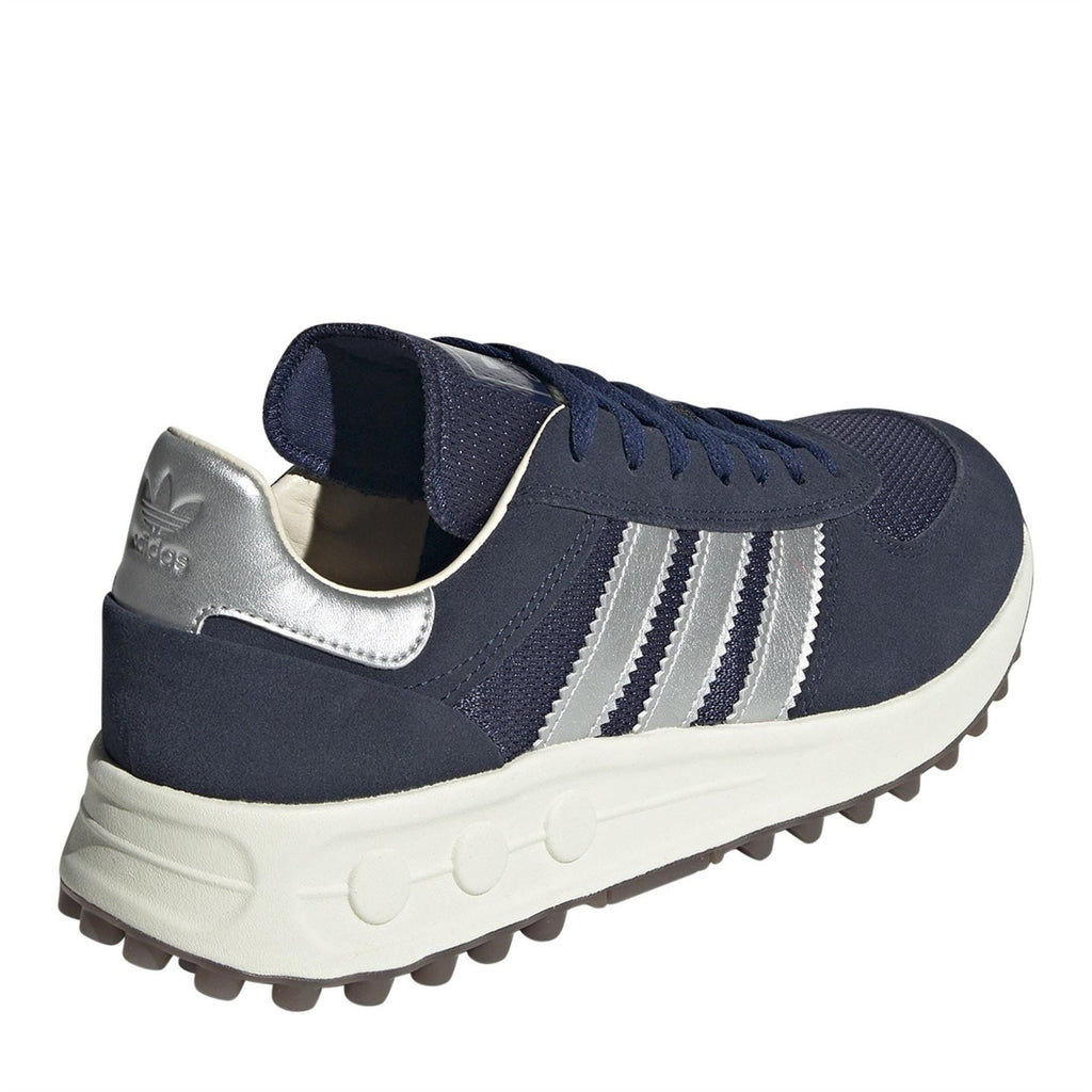 Navy suede trainers with silver heel tab, white stripes, and thick off-white midsole