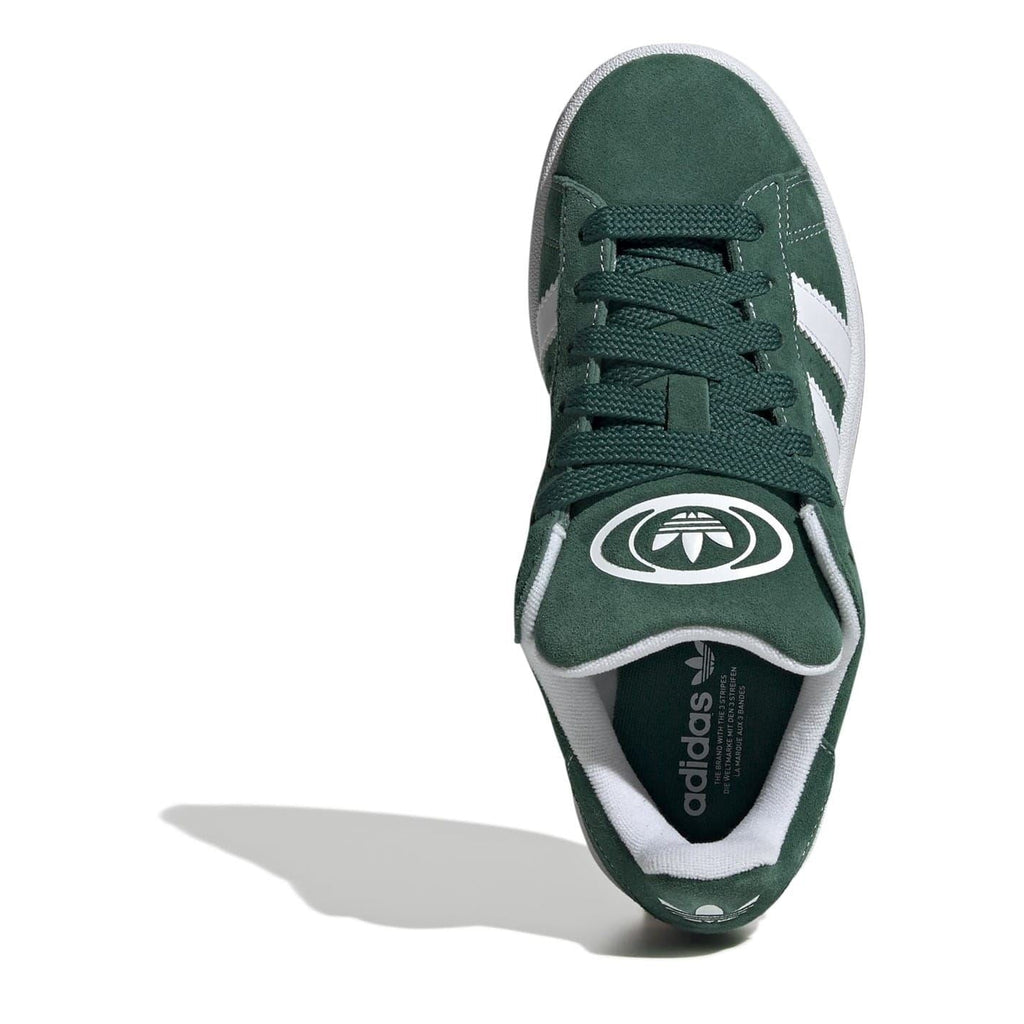Juniors green suede trainers, lace-up front view with white stripes and logo at tongue.