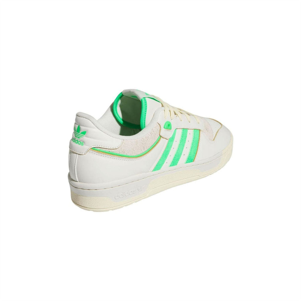 Low-top trainers with white leather-look upper, green collar lining, and heel pull tab