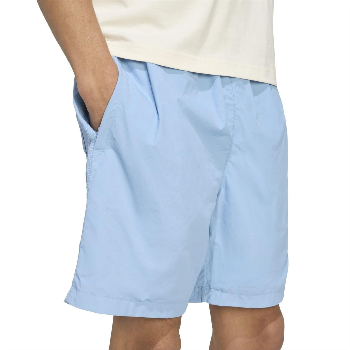 Light blue shorts with side pocket and stitched paneling, elastic waist