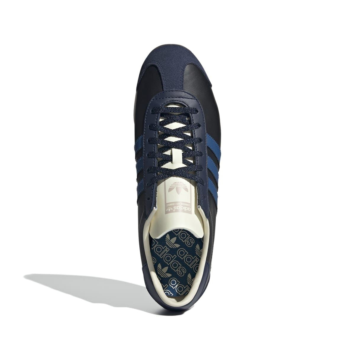 Navy/black lace-up trainer with blue stripes and cream insole label on the tongue