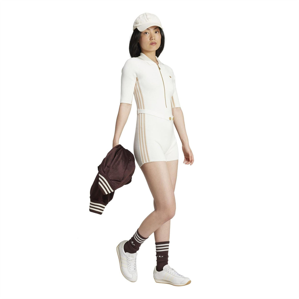 Off-white knit onesie with gold zipper, ribbed cuffs, and vertical stripe side panels