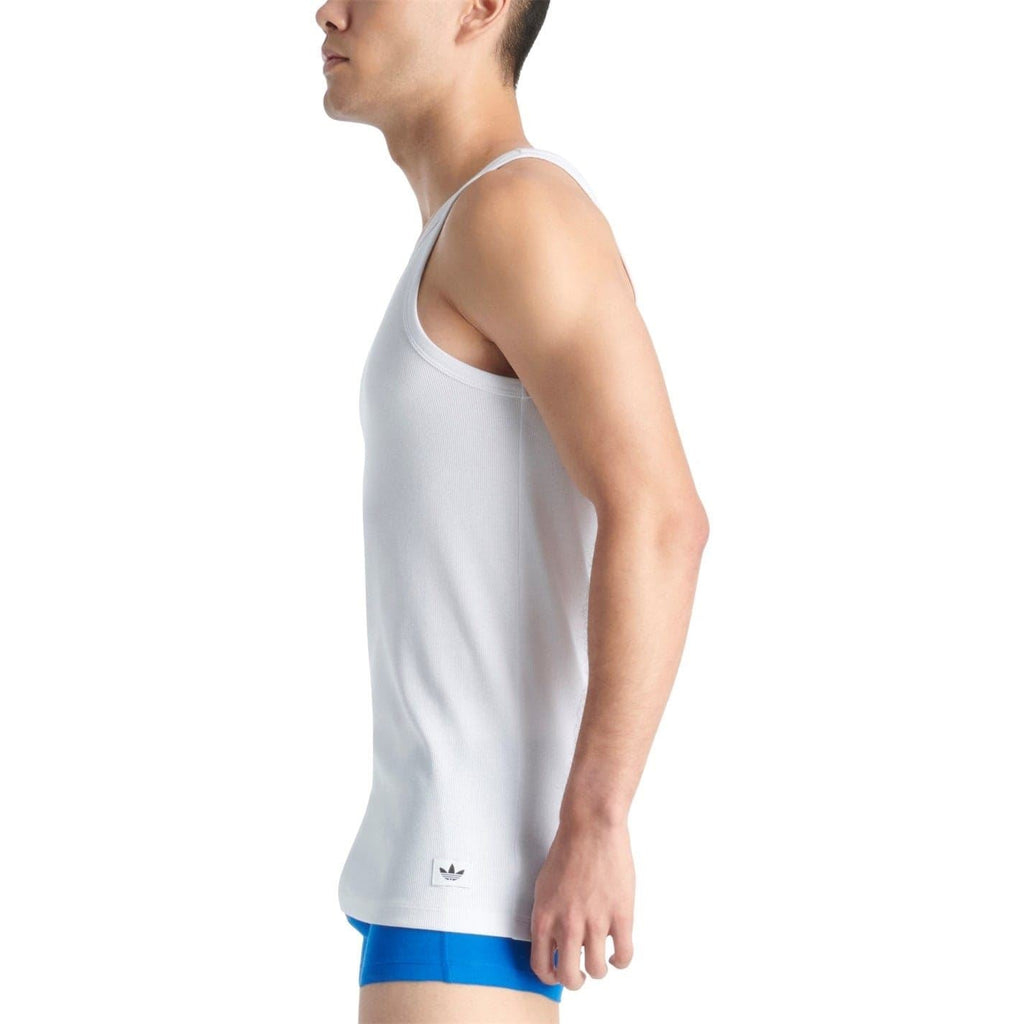 White sleeveless tank top side view with curved hem and small logo near bottom