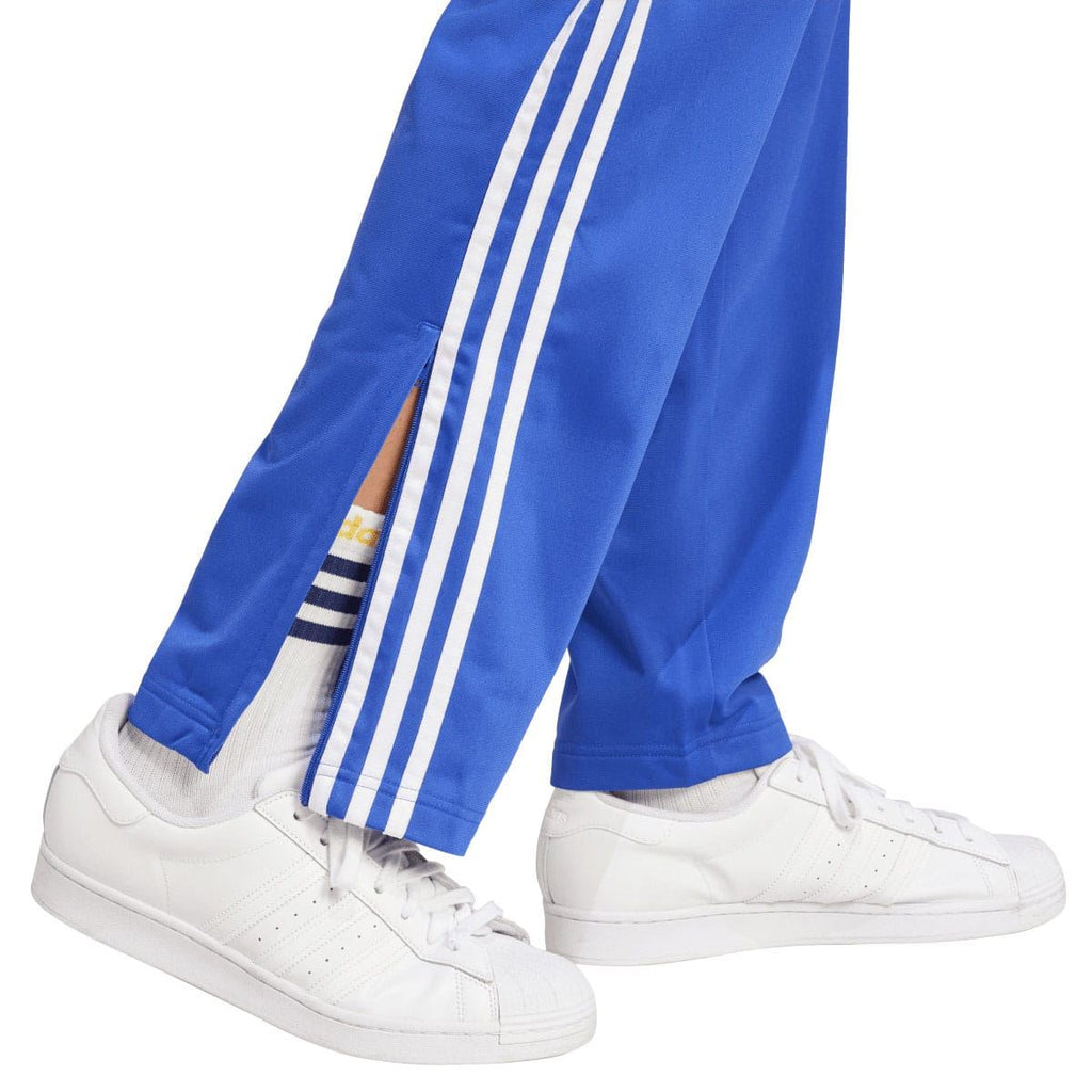 Blue track pants leg with white triple stripe detailing and side seam