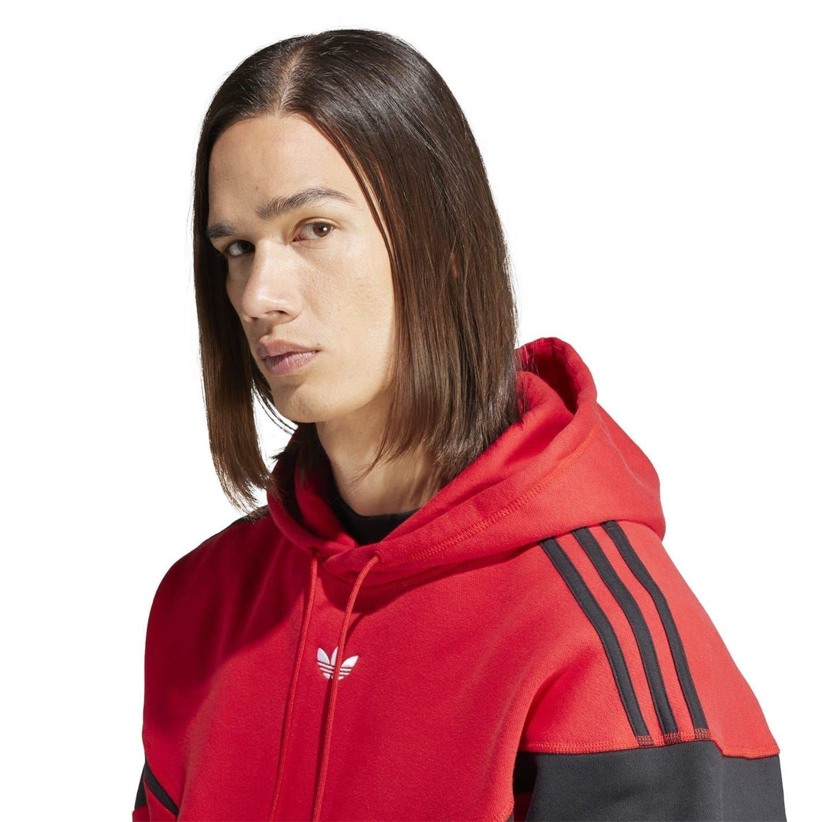 Red hooded sweatshirt close-up with logo on chest and black stripe on sleeve.