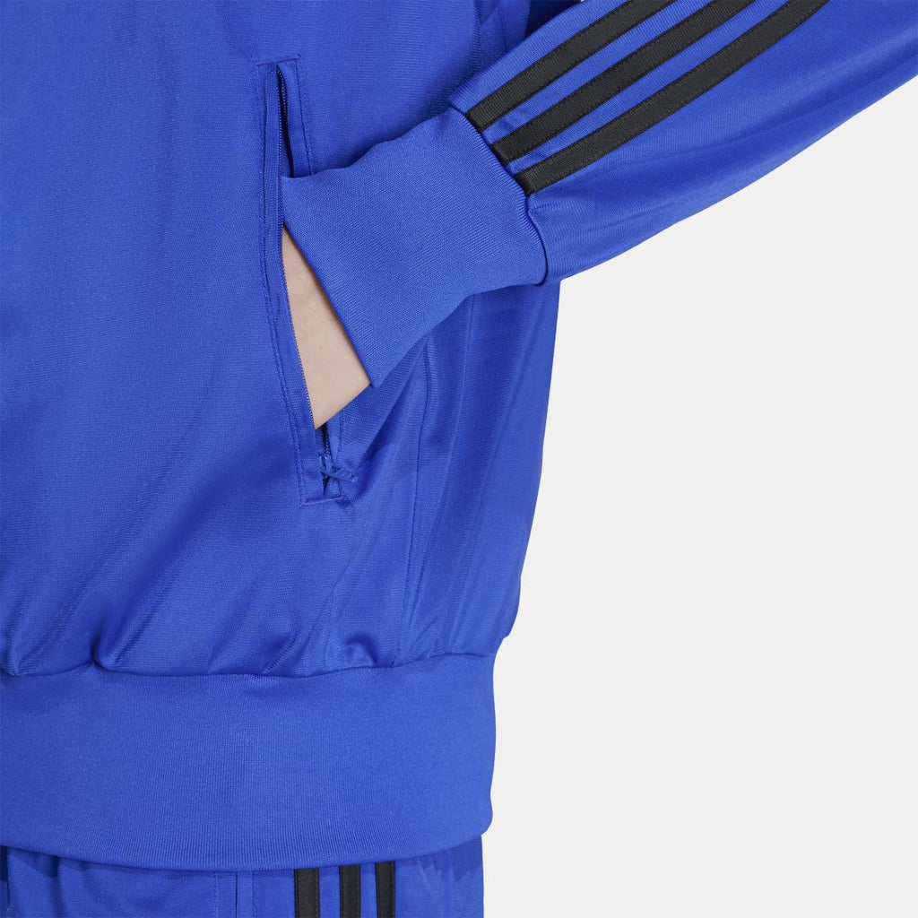 Blue adidas track jacket detail: zip front, pocket, and cuff with black sleeve stripes