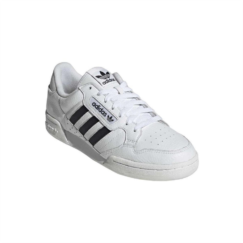 White adidas low-top trainers with black three stripes and grey-tinted trim