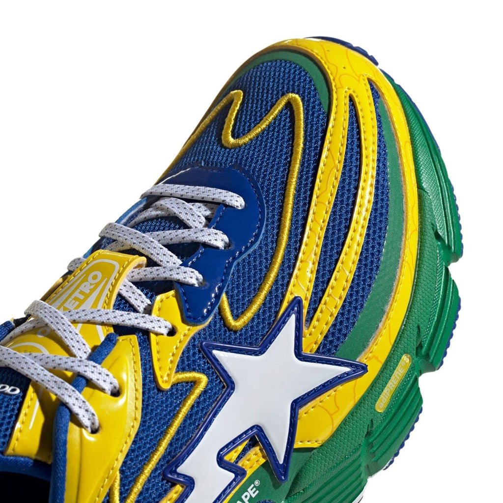 Close-up of blue upper with star emblem, yellow stripes, and green side panel