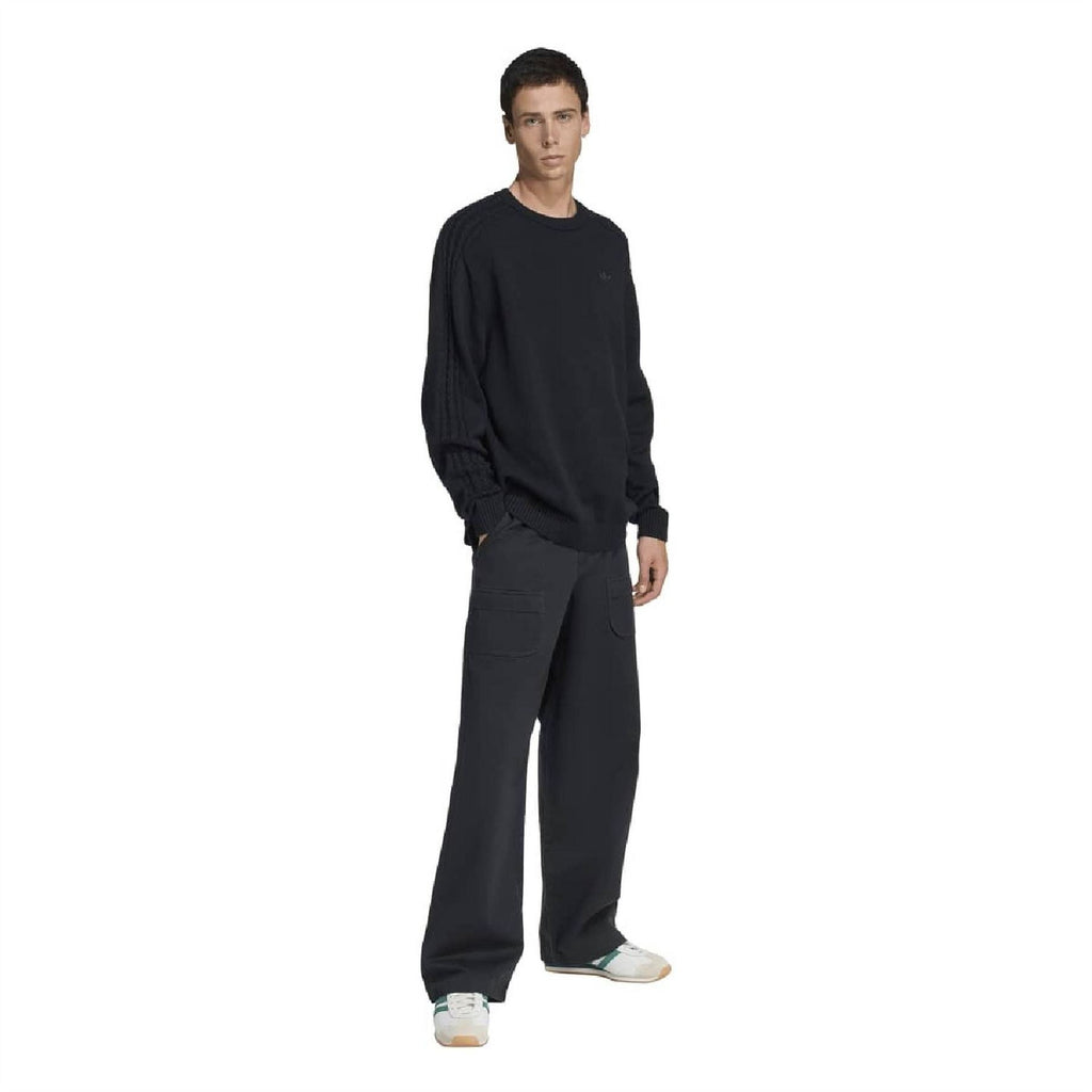 Black crew neck sweater worn with relaxed fit, raglan sleeves and ribbed cuffs