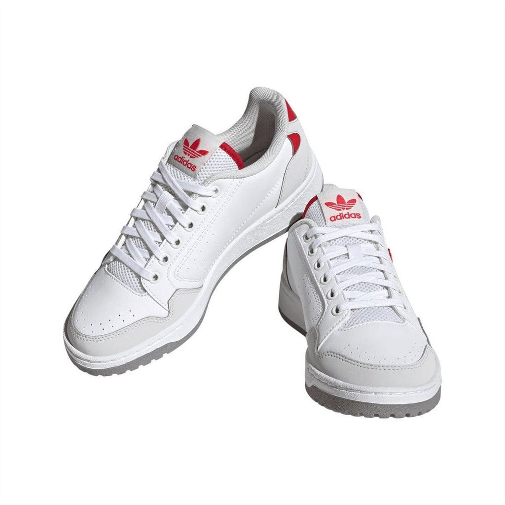 White lace-up trainers with red heel accents and adidas trefoil logo on side