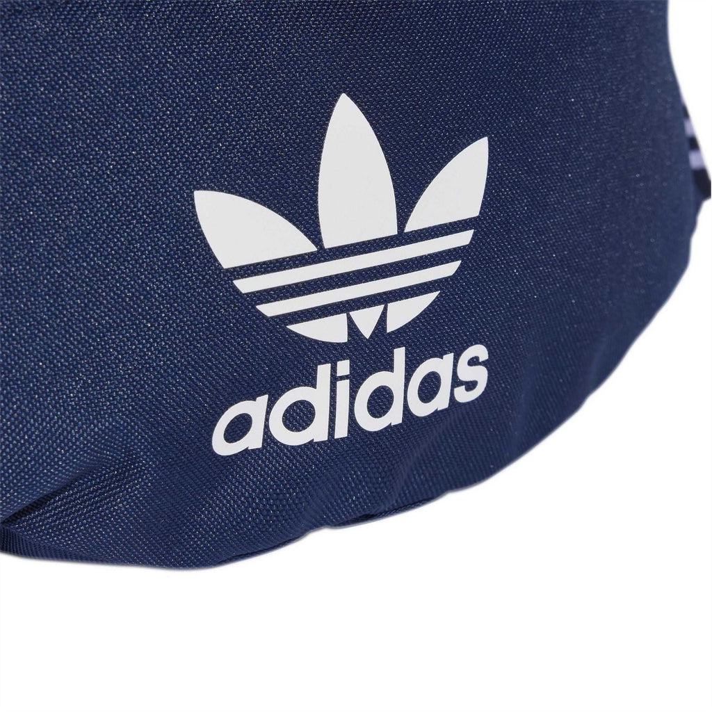 Close-up of dark indigo adidas trefoil logo on front of waist bag