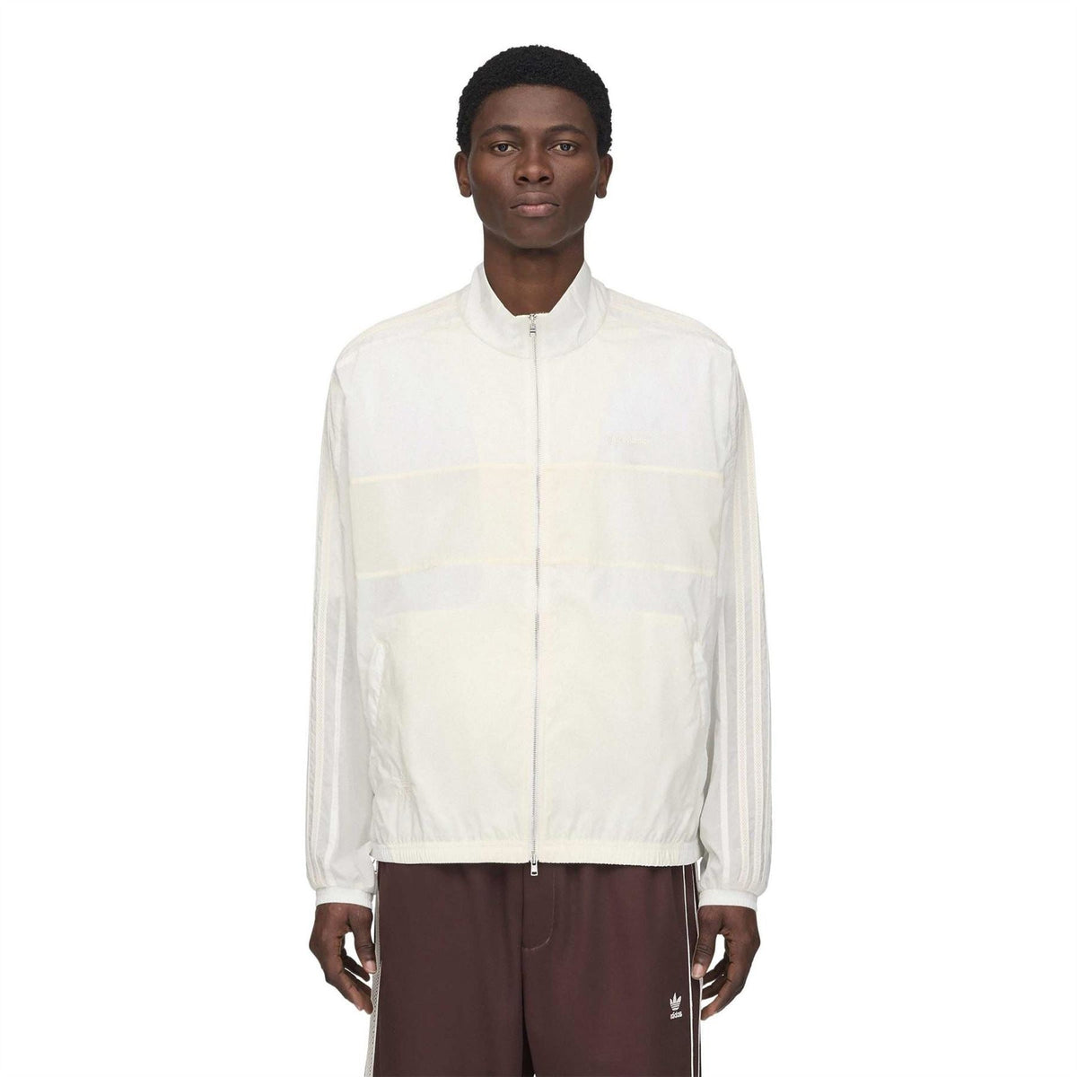 Chalk white track jacket front with stand collar, full zip, and elastic cuffs.