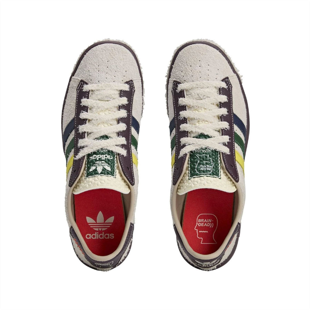 Pair of cream low-top sneakers with white laces, navy stripes and red interior