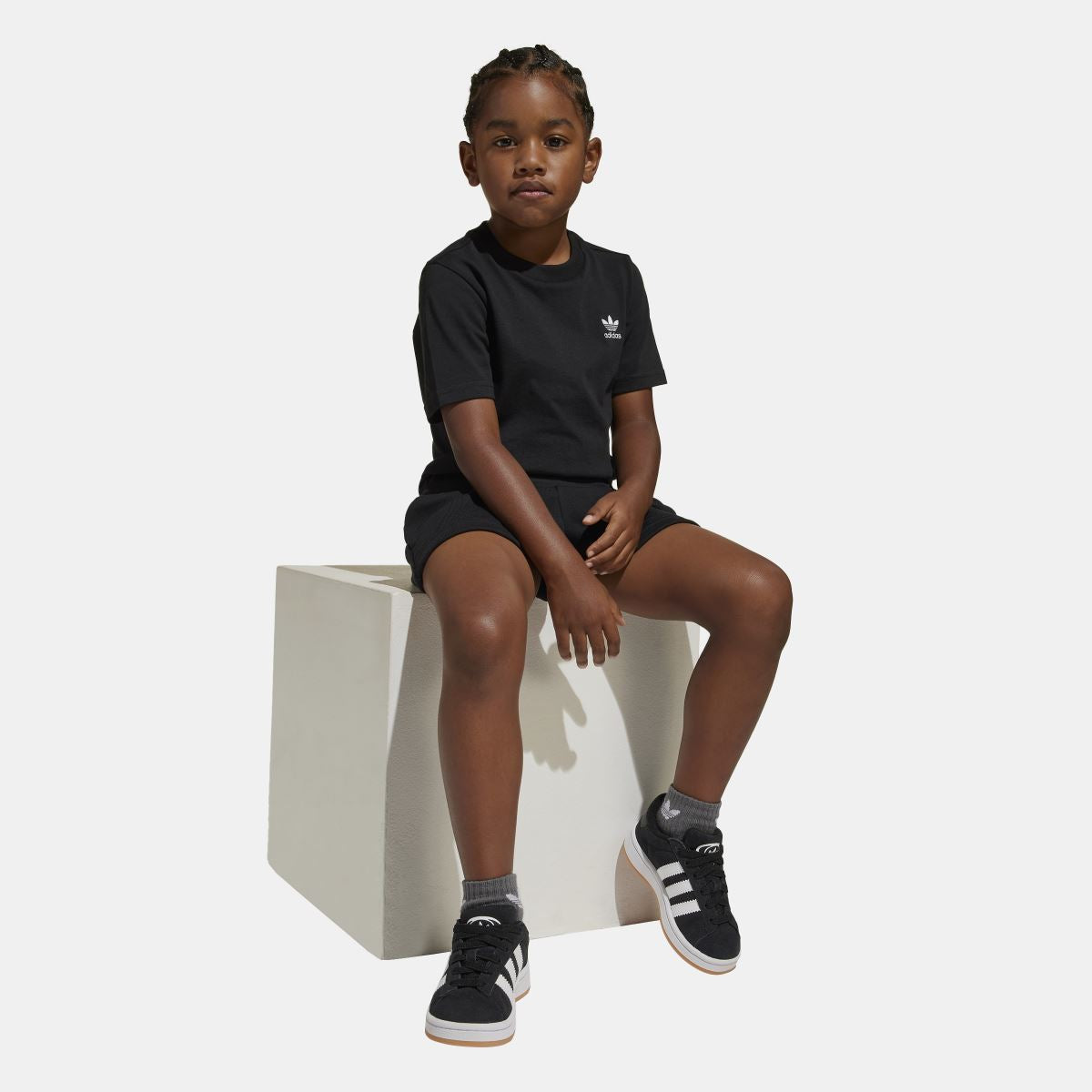 Black adidas juniors T-shirt and shorts set on child sitting