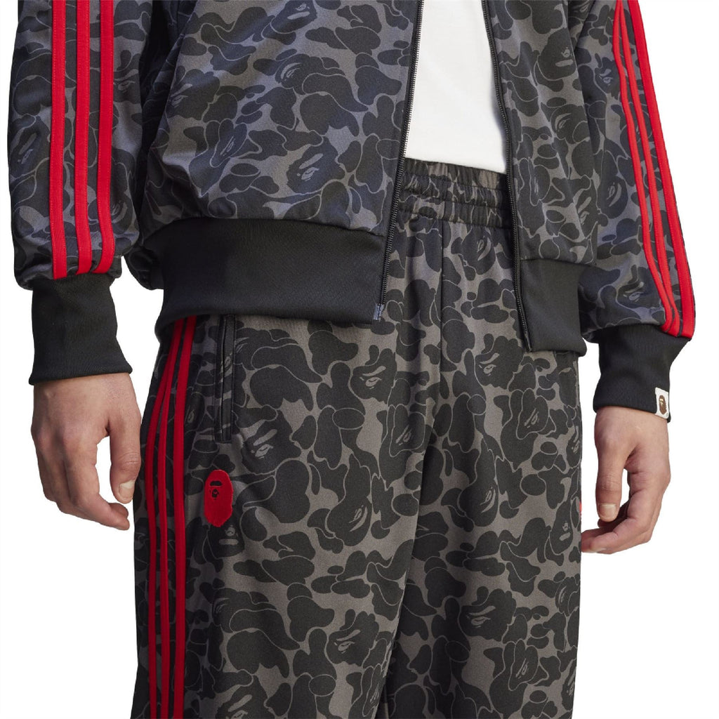 Camo trackpants with elastic waistband and red side stripe panel.