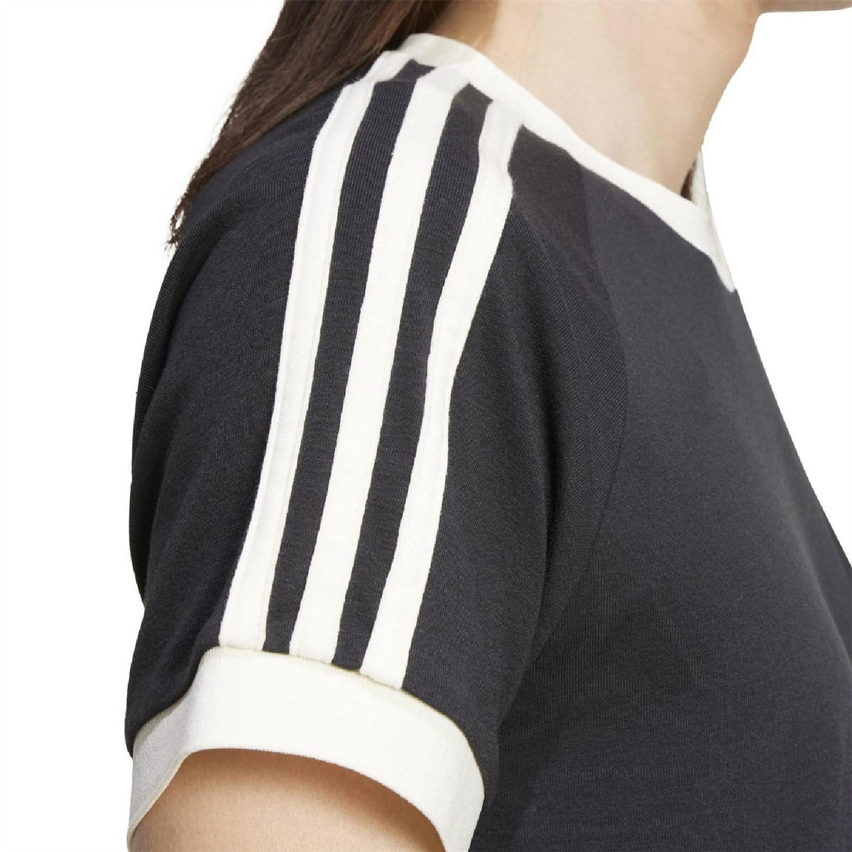 Black adidas T-shirt shoulder detail with bold three white vertical sleeve stripes
