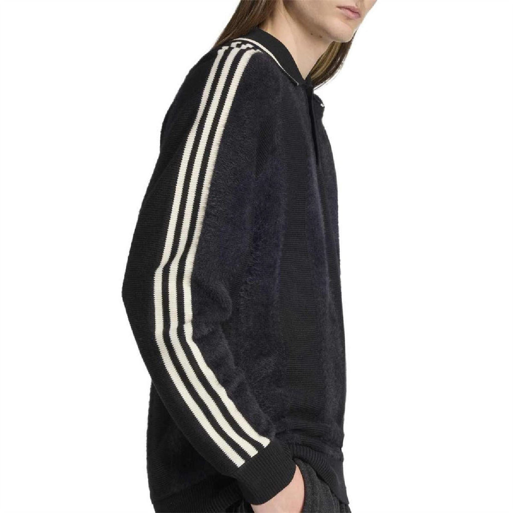 Side view of dark collared raglan sweater with white triple stripe bands on sleeve