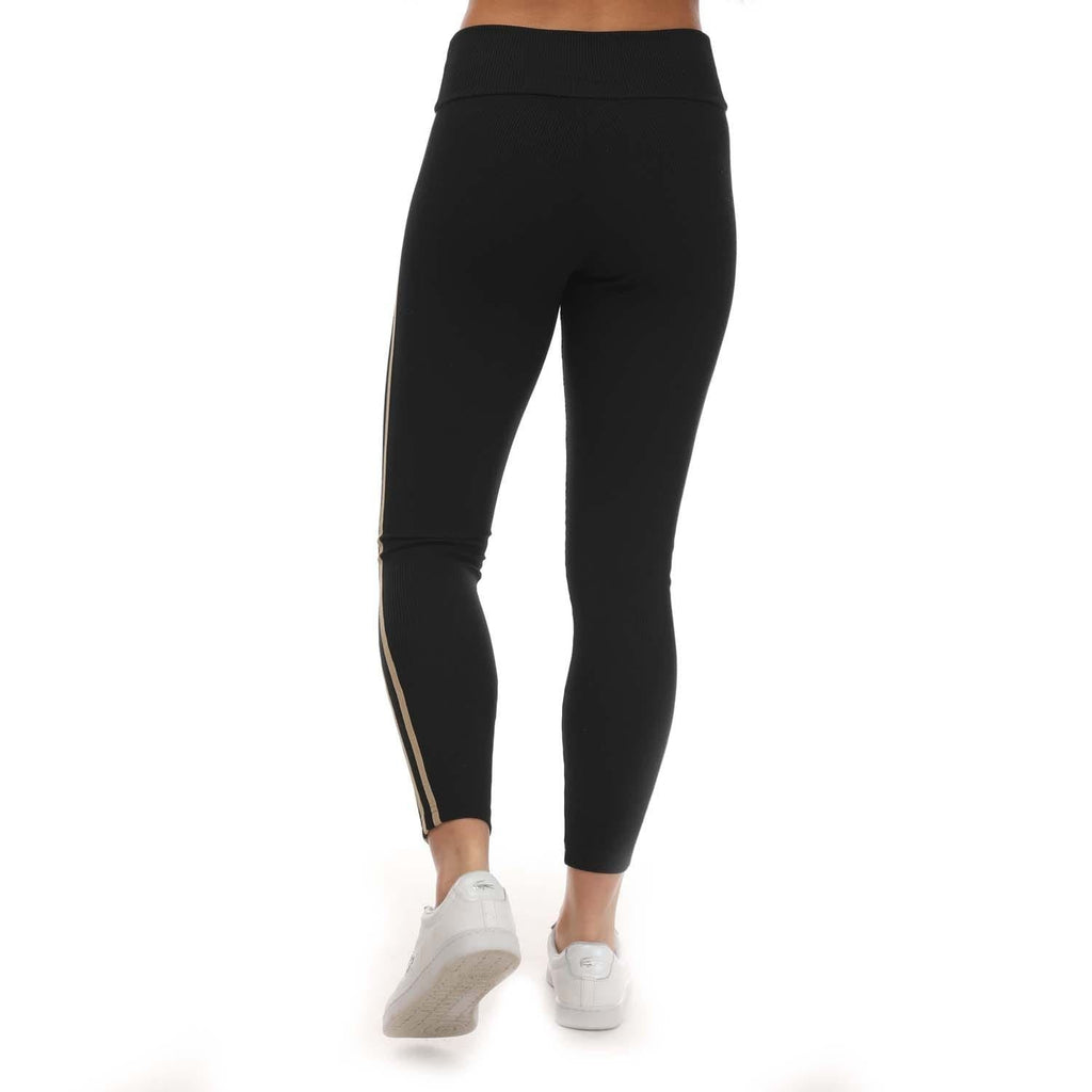 Black leggings with three gold side stripes and tapered ankle fit