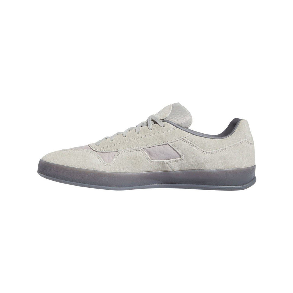 Beige low-top lace-up sneakers with purple stripe overlays and gray outsole