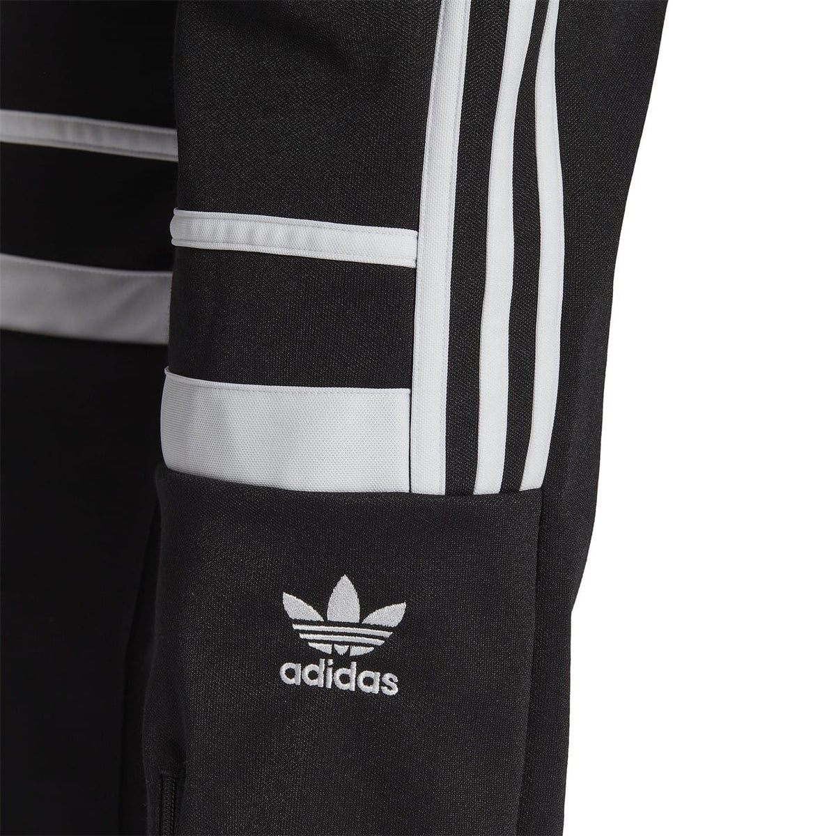 Close-up of black joggers hem with white stripe band and adidas trefoil logo