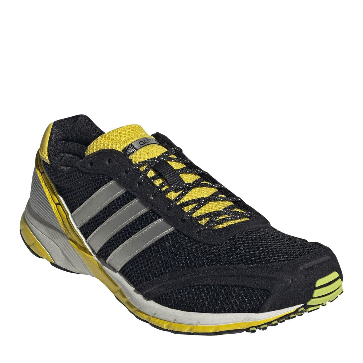 Black low-top sneakers with silver 3-Stripes, yellow laces, and white midsole