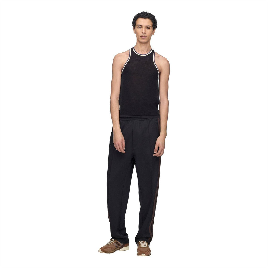 Black knit tank top with contrast trim, worn with black pants