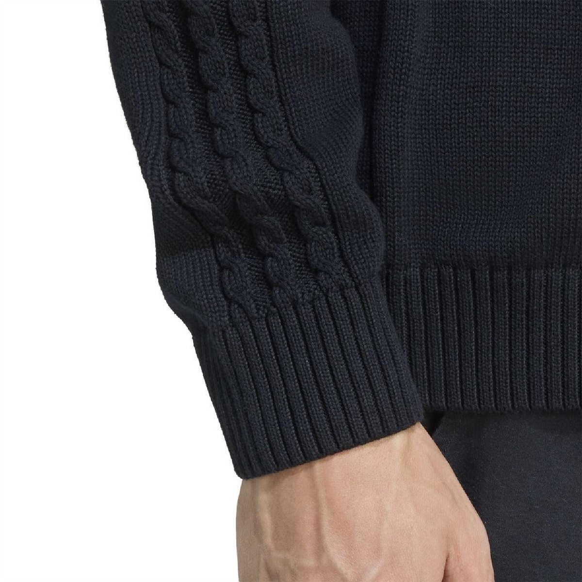 Black raglan sweater sleeve with cable-knit texture and ribbed cuff
