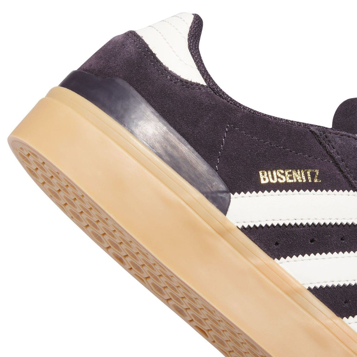 Heel and side view of dark suede trainer with BUSENITZ detail and gum sole