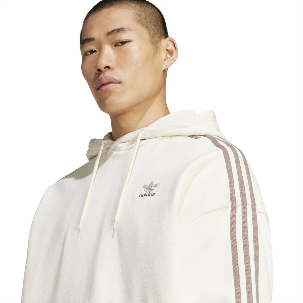 Off-white adidas hoodie with small trefoil logo on chest and three stripe sleeve detail.