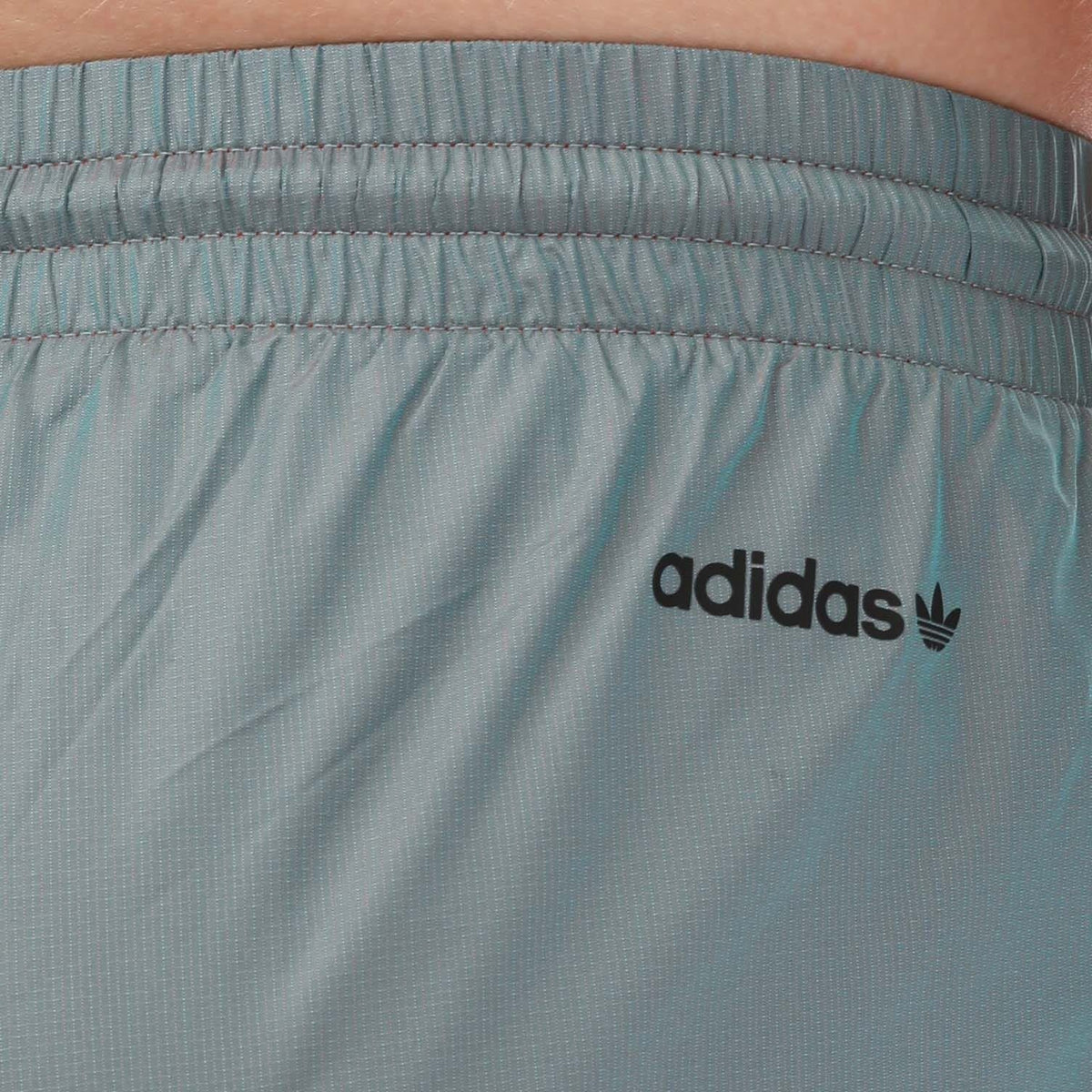 Light blue track pants with adidas wordmark and trefoil logo on back