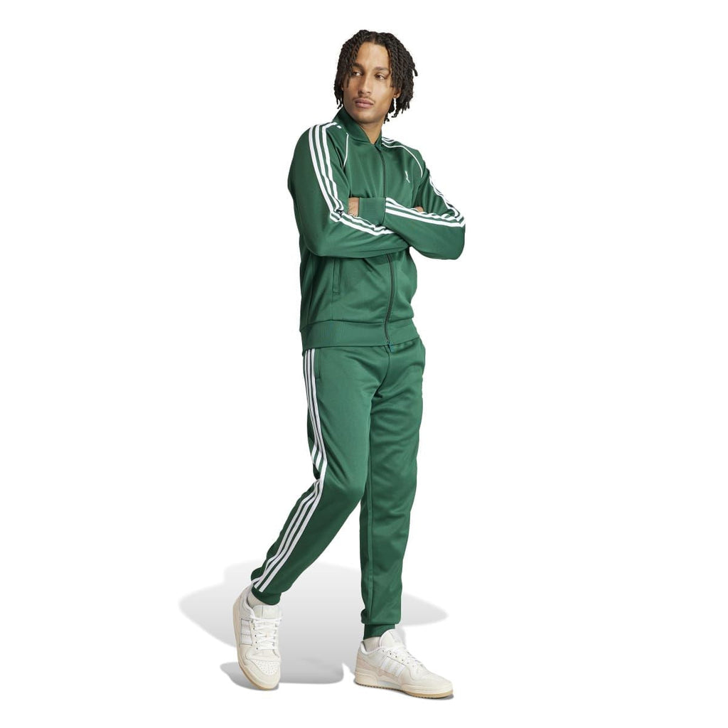 Green adidas track jacket on model with full zip front and white three-stripe sleeves