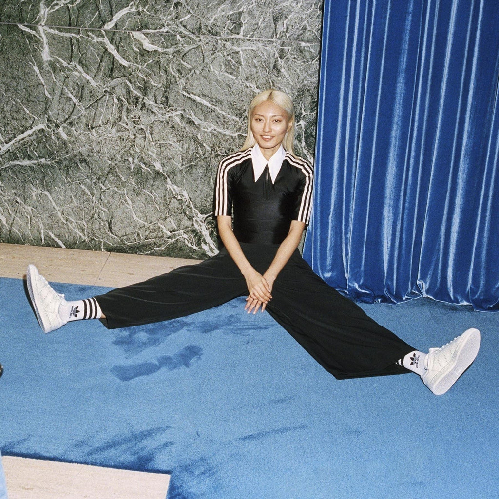 White crew socks with black adidas stripes, worn with sneakers