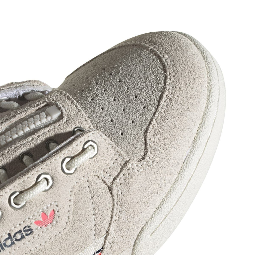 Close-up of light beige suede toe with perforation details and lace hardware