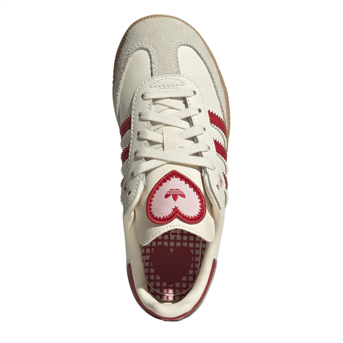Sneaker top view with cream laces and red heel patch, gum sole